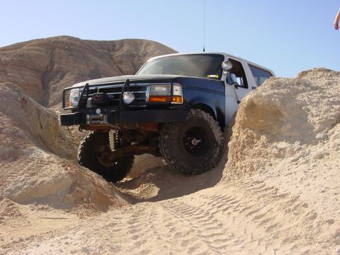 1994 Ford Bronco - This 1994 Ford Bronco is shown off-roading in a desert environment, demonstrating its capabilities.