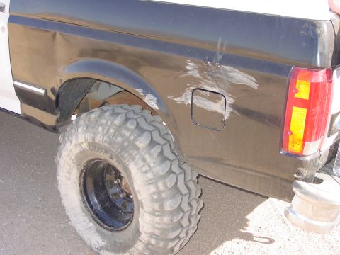 1994 Ford Bronco - This Ford Bronco has significant body damage on its rear quarter panel and a large, tire.