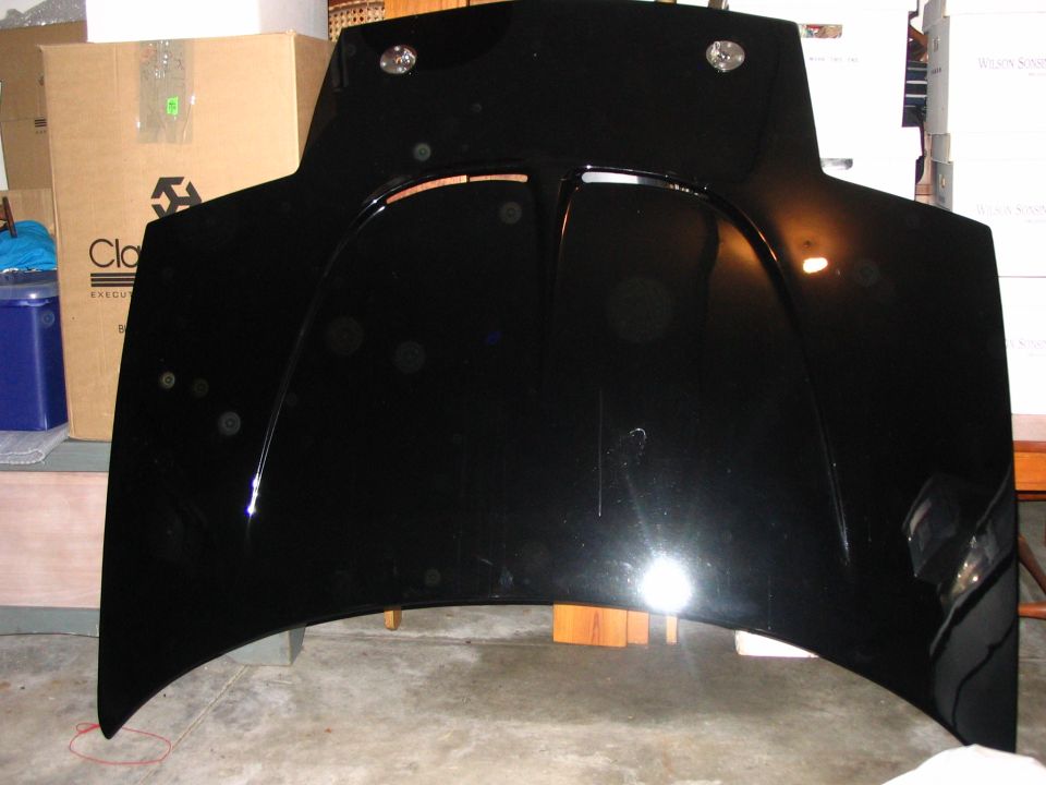 Underside of a black vehicle hood standing in a garage