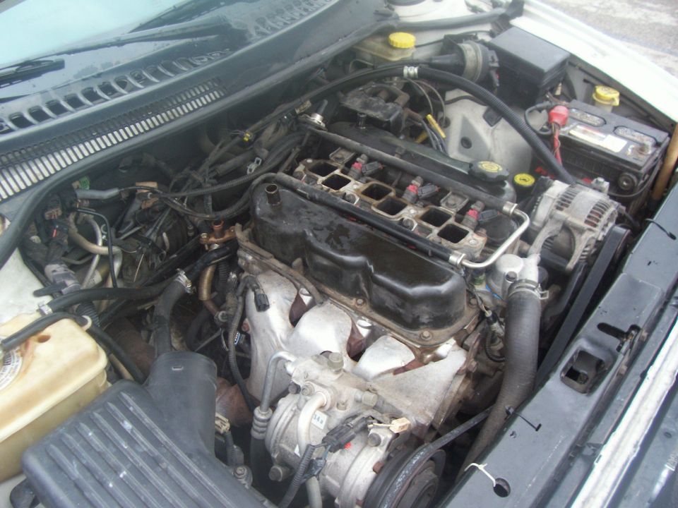 Engine bay with intake manifold removed exposing injectors and intake ports on a V6 engine