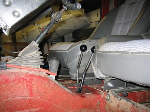1987 Suzuki Samurai - Close-up interior shot showing the dual-stick transfer case shifters and seats of a vehicle.