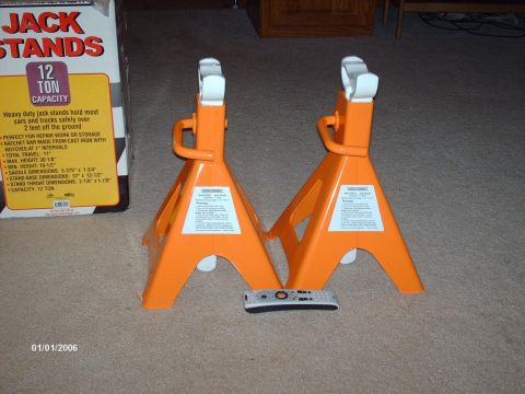 1990 Ford F-150 - A box and two orange jack stands are shown on a carpeted floor with a remote control in front of them.