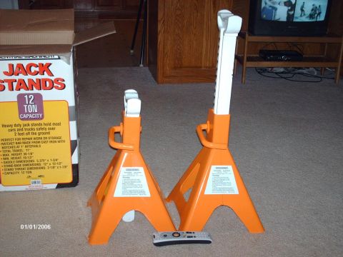 1990 Ford F-150 - A pair of orange jack stands are displayed next to their packaging, which indicates a 12-ton capacity.