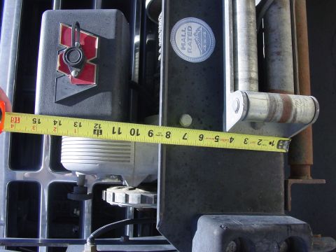 1994 Ford Bronco - A yellow Lufkin tape measure stretched across the front of a truck to check clearance around a bumper-mounted winch, with a black plastic c…