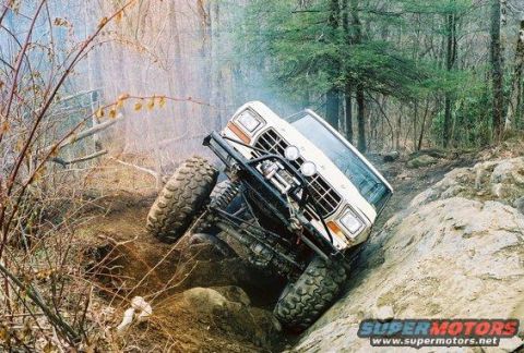 1992 Ford Mustang - Modified off-road truck navigates a steep, rocky incline with large tires and a winch.