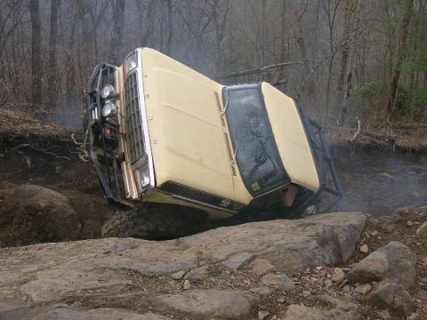 1992 Ford Mustang - This off-road vehicle appears to be stuck on a rocky incline in a wooded area.