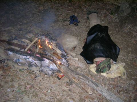 1992 Ford Mustang - A person rests near a campfire, with a can of soda visible on the ground.