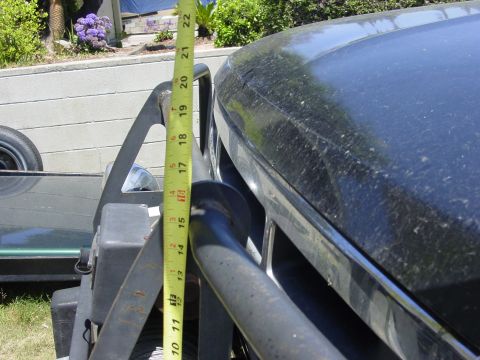 1994 Ford Bronco - A yellow tape measure held vertically from the top of a black tubular winch bumper and brush guard up to the hood edge of a dark green truc…