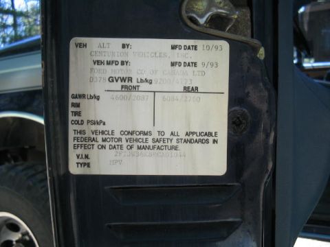 1979 Ford Bronco - Close-up of a vehicle certification/compliance label affixed to a dark blue door jamb, showing MFD dates of 10/93 and 9/93, GVWR 9200/4173,…