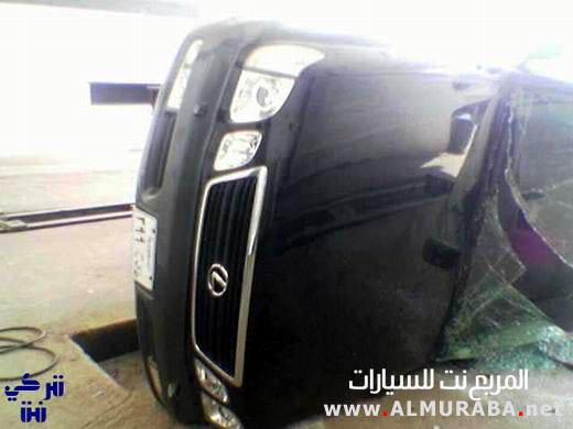 Overturned black car with broken windshield and visible grille