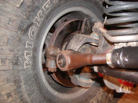 1991 Ford Bronco - Detail of a vehicle's steering and suspension components, including a tire with visible lettering.