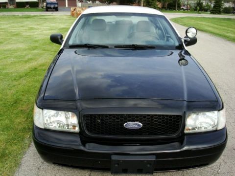 2003 Ford Crown Victoria - Front view of a black and white 2003 Ford Crown Victoria, possibly a police vehicle.