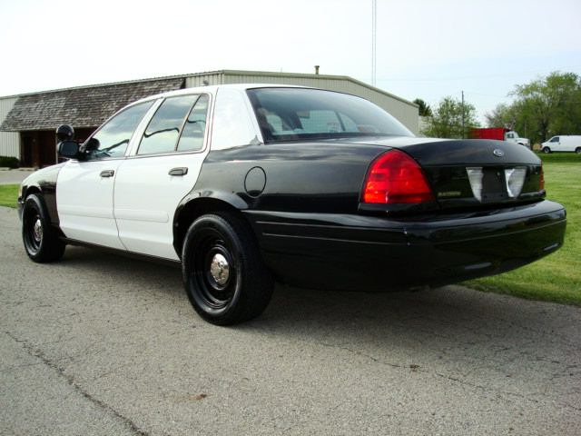Two-tone police car, white front and black rear, parked on asphalt