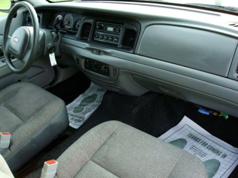2003 Ford Crown Victoria - The interior of a 2003 Ford Crown Victoria, with a focus on the driver's side dashboard and seating area.