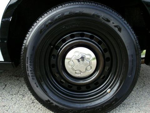 2003 Ford Crown Victoria - Close-up of a chrome Ford hubcap on a black steel wheel, fitted with an Eagle RS-A tire, on a 2003 Ford Crown Victoria.