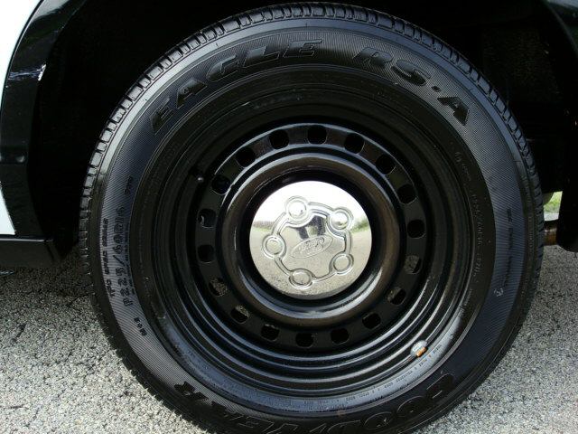 Chrome Ford hubcap on black steel wheel with Eagle RS-A tire on 2003 Ford Crown Victoria