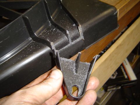 1989 Ford Bronco - Modified plastic bracket with metal tab, likely for an automotive part installation.