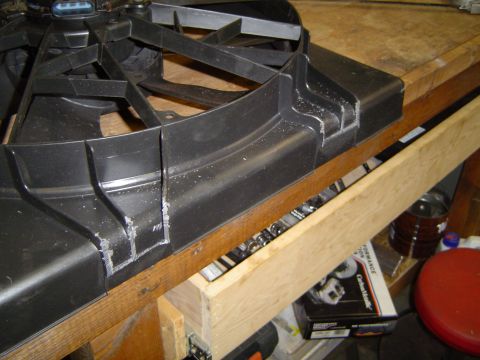 1989 Ford Bronco - A modified electric fan shroud sits on a wooden surface, possibly for installation.