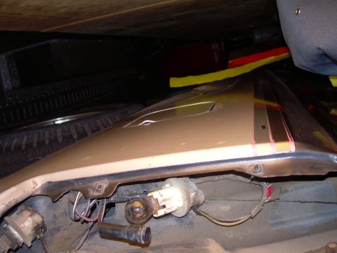 1986 Ford Bronco - Close-up of a car's fender with visible wiring and a light bulb socket.