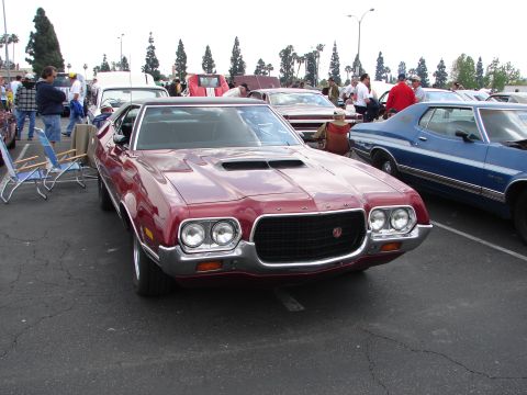 1992 Ford Taurus - A red 1970 Ford Torino GT is parked at an outdoor car show, with other vehicles visible in the background.