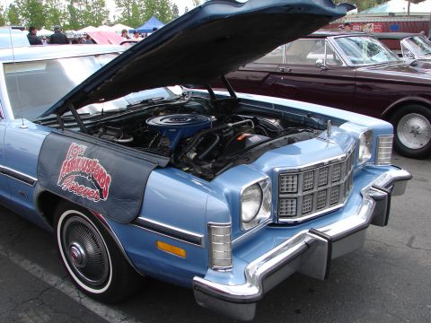 1992 Ford Taurus - A blue classic car's engine is exposed under its open hood, with a decorative fender cover.