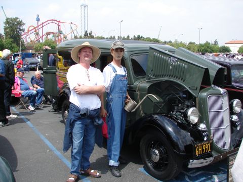 1992 Ford Taurus - Man and mannequin pose with a vintage 1935 Ford truck at an outdoor car show.
