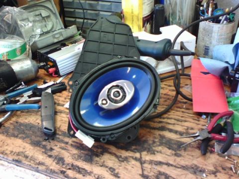 2003 Toyota Tacoma - A car speaker and various tools are laid out on a wooden surface, suggesting a repair or installation project.