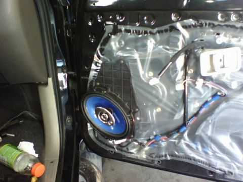 2003 Toyota Tacoma - The interior of a car door is exposed, revealing the speaker and its wiring harness.
