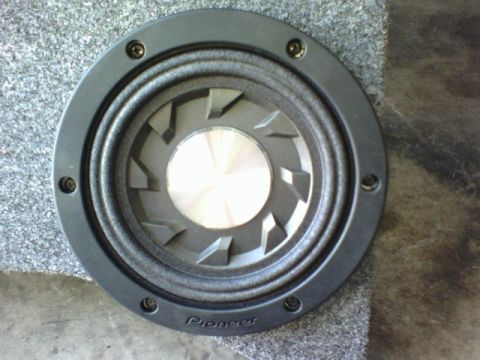 2003 Toyota Tacoma - A Pioneer speaker is shown mounted in a gray carpeted enclosure.