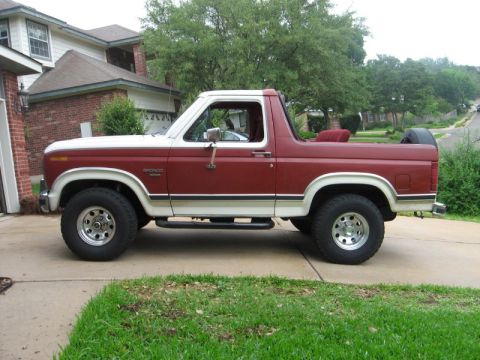 1986 Ford Bronco - This two-tone Ford Bronco is parked on a suburban driveway.