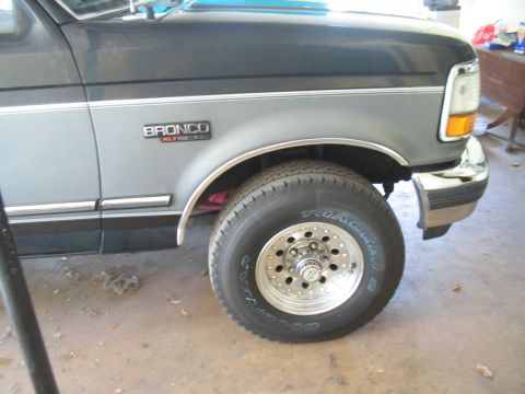 1992 Ford Bronco - Close-up of a 1992 Ford Bronco's front fender, showing the wheel and part of the bumper.
