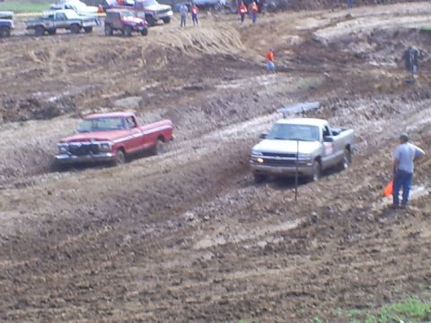 2001 Dodge 1500 - Pickup trucks compete in a mud race event on a dirt track.