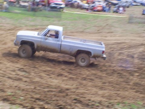2001 Dodge 1500 - A silver pickup truck navigates a muddy track during an event.
