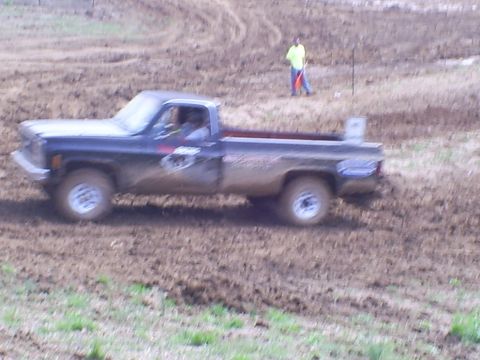 2001 Dodge 1500 - A pickup truck navigates a muddy track during a race event.