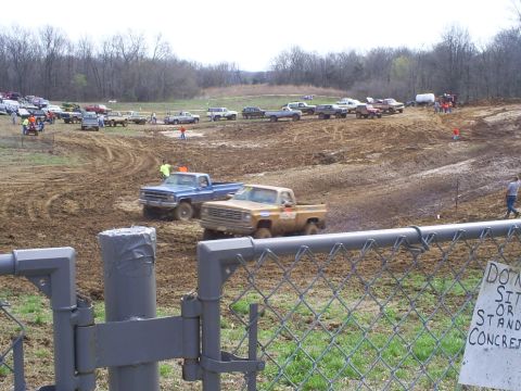 2001 Dodge 1500 - Multiple trucks participate in a mud bogging event on a dirt track.