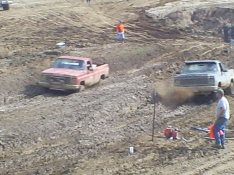 2001 Dodge 1500 - Two pickup trucks navigate a challenging mud course during an event.