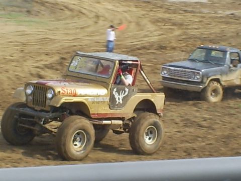2001 Dodge 1500 - Two modified off-road vehicles, a Jeep and a Dodge pickup, compete on a dirt track.