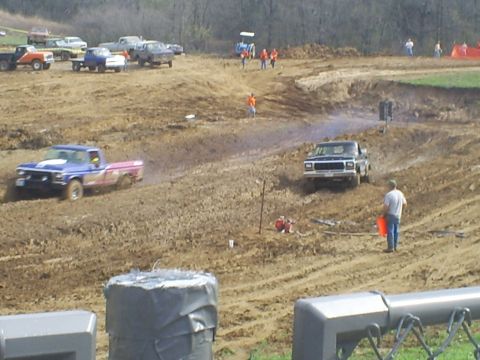 2001 Dodge 1500 - Trucks compete in a mud race, navigating a challenging dirt track.