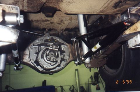 1985 Ford Bronco - Close-up view of the rear differential and suspension system, black shocks and silver springs.
