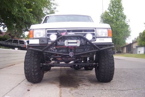 1989 Ford Bronco - Front view of a modified Ford truck with off-road tires and a winch mounted on a custom bumper.