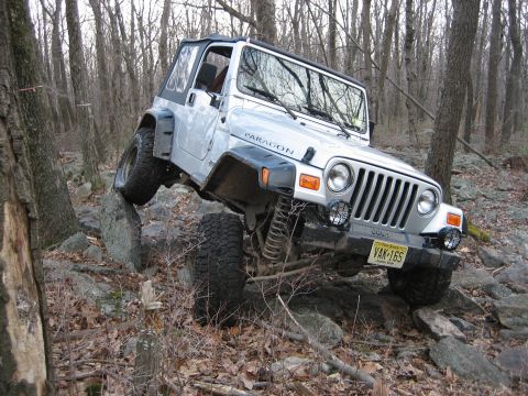 2002 Jeep Wrangler - This silver 2002 Jeep Wrangler tackles a challenging rocky trail, demonstrating its off-road capabilities.