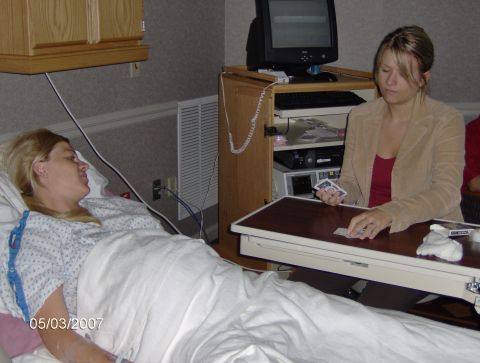 1978 Ford Bronco - A patient in a hospital gown lies in bed while a visitor plays cards with them.