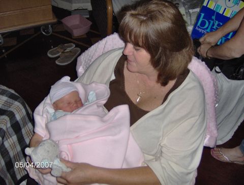 1978 Ford Bronco - A woman cradles a baby, who is swaddled in a pink blanket and wearing a striped hat.