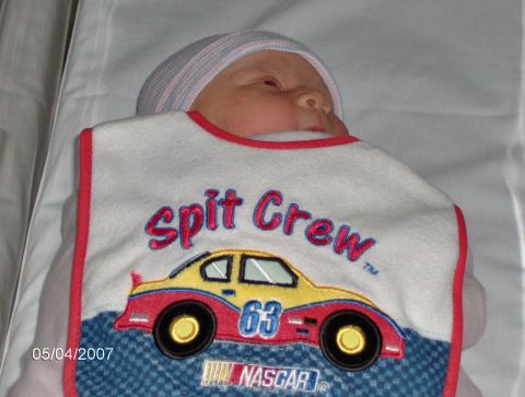 1978 Ford Bronco - A baby is shown wearing a bib with a NASCAR theme and the number 63.