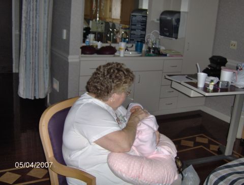1978 Ford Bronco - A woman cradles a baby in a hospital room setting.