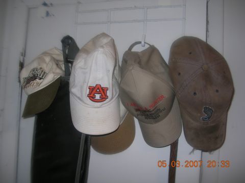 1991 Ford F-150 - A collection of baseball caps hangs on a wall rack, including one with an Auburn University logo.
