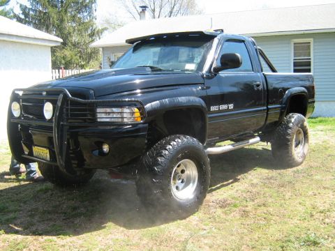 1990 Ford Bronco - This lifted Dodge Ram 1500 pickup truck features a bull bar and custom wheels.