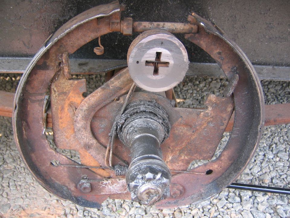 Trailer brake drum assembly with rusted components and a large central nut