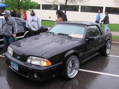 1998 GMC Sierra 1500 - Black convertible sports car with wire wheels on a rainy day.