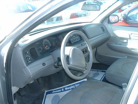 2000 Ford Crown Victoria - The interior of a 2000 Ford Crown Victoria is shown, the dashboard and driver's seat.
